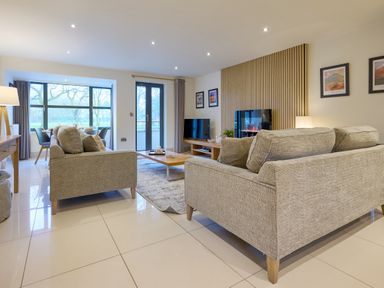 A living room with sofas and a television at Riverside Park 1 in Keswick
