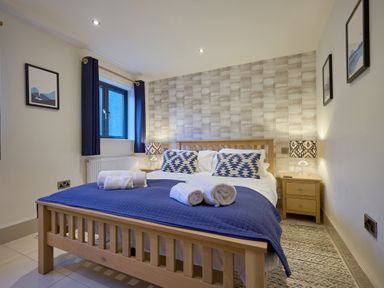A bedroom with a bed and bedside table at Riverside Park 1 in Keswick