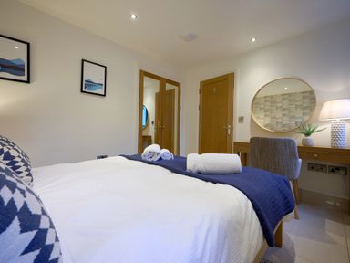 A bedroom with a bed, desk, and lamp at Riverside Park 1 in Keswick