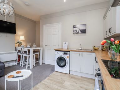 A kitchen area with a table and chairs at 24 Baxtergate in Whitby