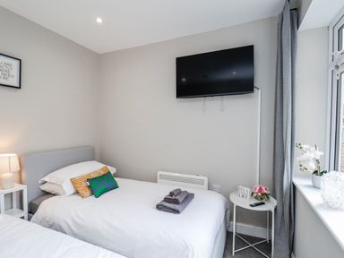 A bedroom with beds and a television at 24 Baxtergate in Whitby