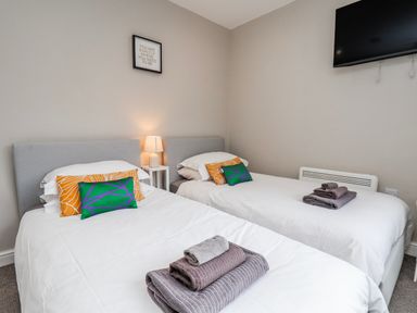 A bedroom with twin beds and a lamp at 24 Baxtergate in Whitby