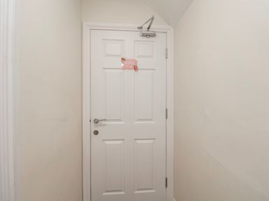 A door with a sign in a hallway at 24 Baxtergate in Whitby