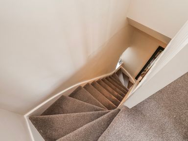 A staircase with a handrail and carpet at 24 Baxtergate Whitby