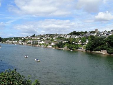 A riverside view with houses along the shore and boats on the water at Meadow Lodge in Newton Ferrers
