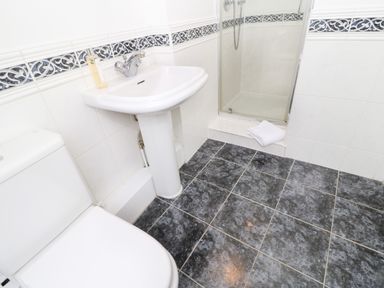 A bathroom with a toilet sink and shower with towel on the step at Toll House in Corbridge