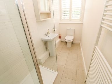 A bathroom with a shower cubicle sink toilet window and radiator at Toll House in Corbridge