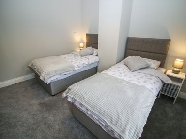 A bedroom with two single beds and bedside lamps at Pebble Lodge in Kenmare County Kerry