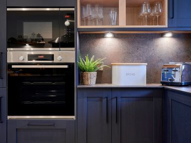 A kitchen counter with a built in oven and microwave a bread box a toaster and glassware at Riverside Park 2 Keswick
