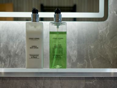 Two bottles of hand and body lotion and hand wash on a bathroom shelf at Riverside Park 2 in Keswick