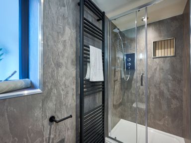 A bathroom with a glass shower enclosure and a black towel rack at Riverside Park 2 in Keswick