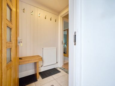 A hallway with hooks and a bench at Riverside Park 3 in Keswick