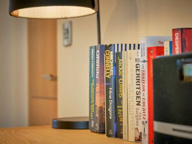 A book shelf with various books and a lamp at Riverside Park 3 in Keswick