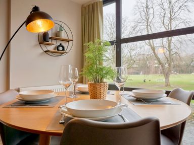 A dining room with a round table set for dinner at Riverside Park 3 in Keswick