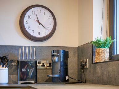 A kitchen with a clock and coffee maker at Riverside Park 3 in Keswick