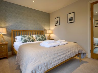 A bedroom with a bed and bedside table at Riverside Park 3 Keswick