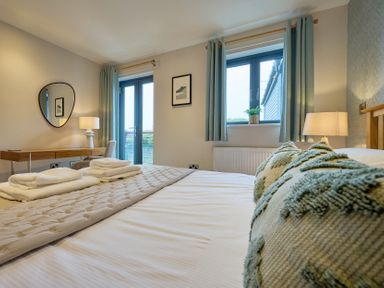 A bedroom with a bed and windows at Riverside Park 3 in Keswick