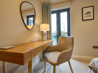 An office with a desk, chair, lamp and mirror at Riverside Park 3 in Keswick
