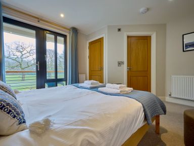A bedroom with a bed and two doors at Riverside Park 3 in Keswick
