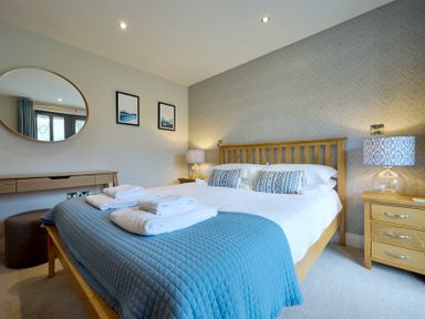 A bedroom with a double bed and wooden furniture at Riverside Park 3 in Keswick
