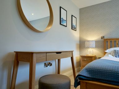A bedroom with a bed, desk, and lamp at Riverside Park 3 in Keswick