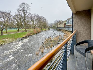 A river flowing near buildings and trees at Riverside Park 3 in Keswick