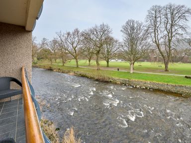 A view from a balcony overlooking a river and park at Riverside Park 3 in Keswick