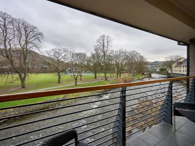 A balcony view of a river and trees at Riverside Park 5 in Keswick