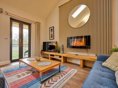 A living room with a television and sofa at Riverside Park 5 in Keswick