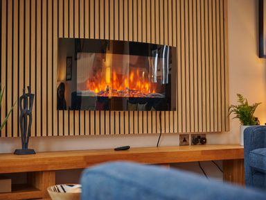 A living room with an electric fireplace and wood paneling at Riverside Park 5 Keswick