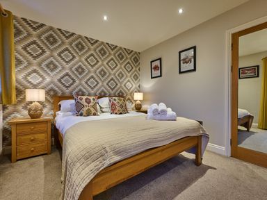 A bedroom with a bed and nightstand at Riverside Park 5 in Keswick