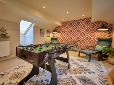 A game room with a foosball table and chairs at Riverside Park 5 in Keswick