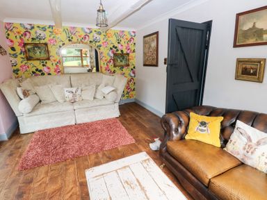 A living room with a sofa and armchair at The Woodlands Lower Level in Stepaside