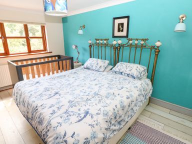 A bedroom with a bed and crib at The Woodlands Lower Level in Stepaside