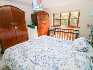 A bedroom with a bed, wardrobe, and crib at The Woodlands Lower Level, Stepaside