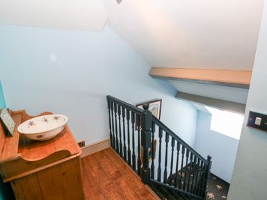 A staircase with a wash basin and wooden storage unit at The Woodlands Lower Level Stepaside