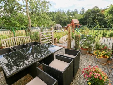 A seating area with a table and chairs in a garden at The Woodlands Lower Level, Stepaside