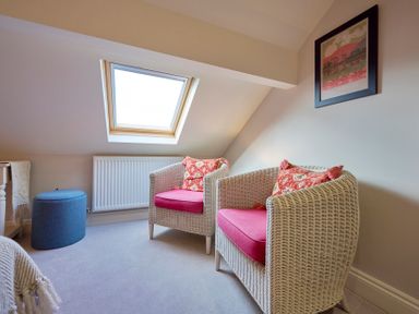 A room with two wicker armchairs with pink cushions and a skylight window at Riverside Park 6 in Keswick