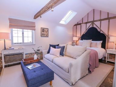 A bedroom with a bed and sofa under a skylight at The Forge in Old Newton near Stowmarket