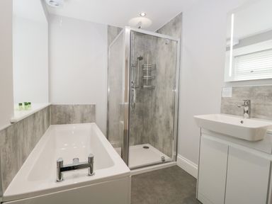 A bathroom with a bathtub shower enclosure and sink at Bill's Barn Oxen Park near Ulverston