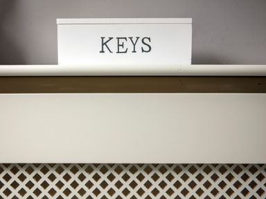 A white box with the word KEYS on a white shelf above a lattice panel at 1 Wesley Mews in Alnwick