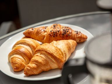 A white plate with three croissants on a glass table at 1 Wesley Mews in Alnwick
