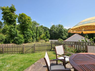 A garden with a table and chairs at Columbine Cottage in Bude