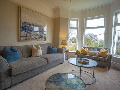 A sitting room with sofas and large windows at Argoed in Abersoch