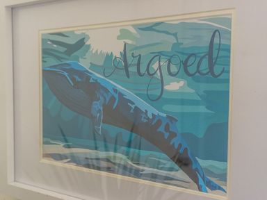 A framed artwork of a blue whale with the word Argoed in stylized text