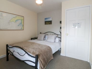 A bedroom with a bed and wall decor at Bryn Awel in Mynytho near Abersoch
