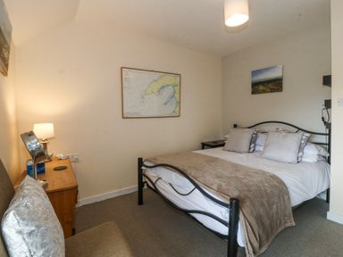A bedroom with a bed and table at Bryn Awel Mynytho near Abersoch