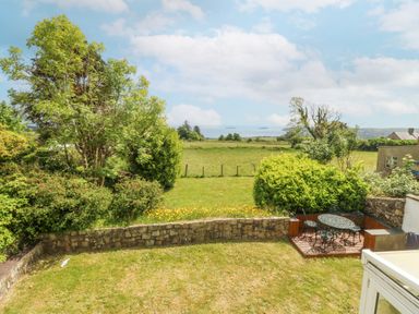 A garden with a table and chairs at Bryn Awel in Mynytho near Abersoch