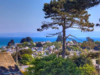 A coastal village with houses trees and the sea in the background at Gilfach in Abersoch