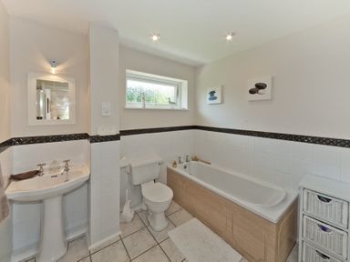 A bathroom with a sink toilet bathtub and storage unit at 3 Madoc View in Bwlchtocyn near Abersoch